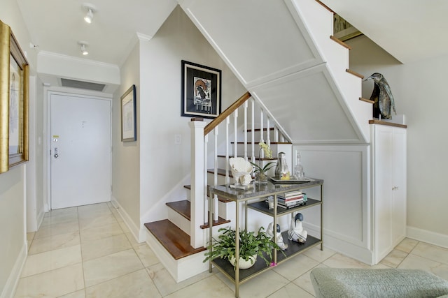 interior space with tile patterned flooring, crown molding, stairway, and baseboards