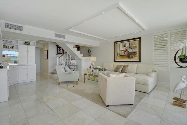 living room featuring visible vents and stairs