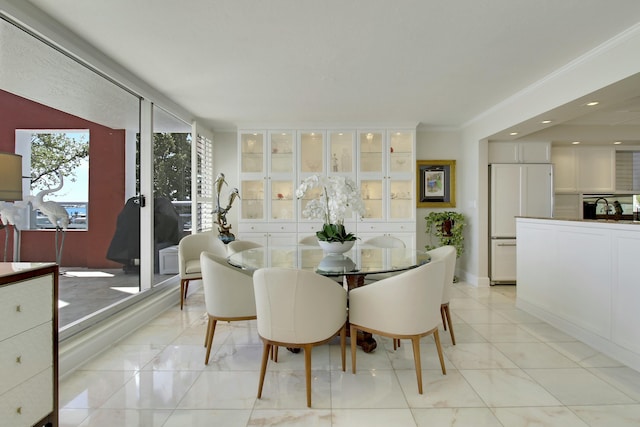 dining space with light tile patterned floors and crown molding