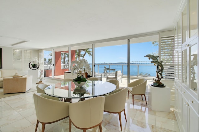 dining room featuring expansive windows, a water view, and light tile patterned flooring