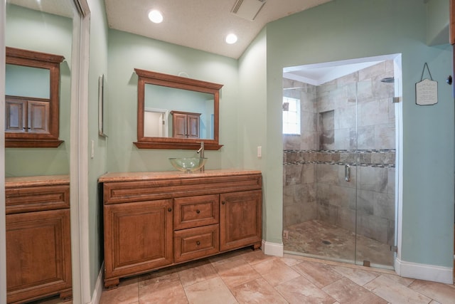 bathroom featuring a stall shower, baseboards, visible vents, and vanity