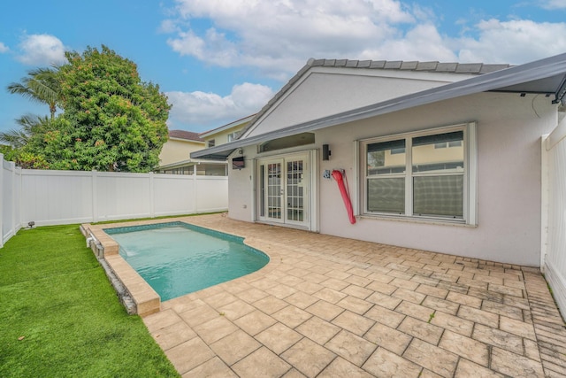 view of swimming pool with a fenced in pool, french doors, a fenced backyard, a yard, and a patio area