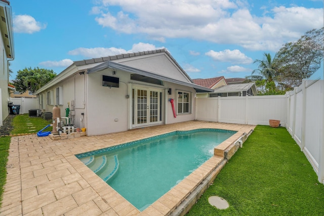 back of property with a lawn, a patio, a fenced backyard, french doors, and stucco siding