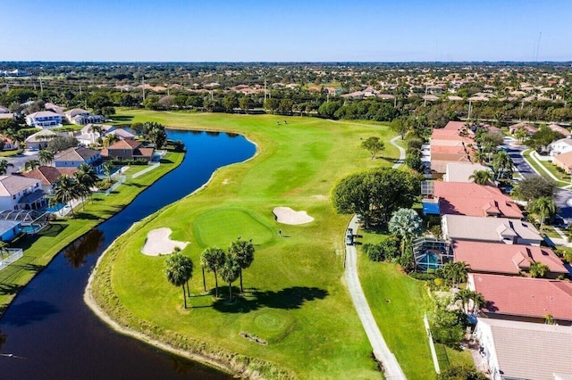 drone / aerial view with a water view, view of golf course, and a residential view