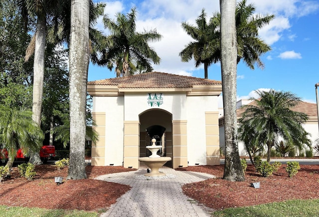 exterior space with a tile roof and stucco siding