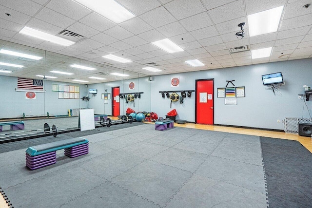 gym with a paneled ceiling and visible vents