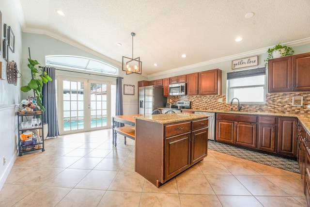 kitchen with light tile patterned flooring, a kitchen island, appliances with stainless steel finishes, and french doors