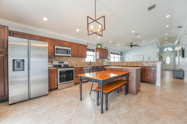 kitchen with stainless steel appliances, a peninsula, backsplash, and visible vents