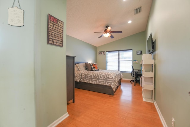 bedroom featuring light wood-type flooring, baseboards, visible vents, and vaulted ceiling