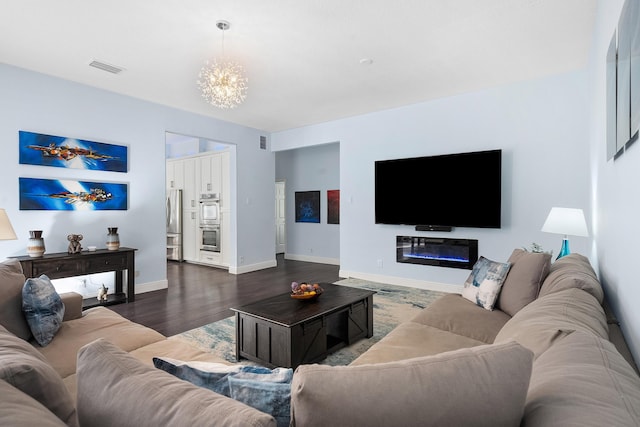 living area featuring an inviting chandelier, baseboards, visible vents, and dark wood-style flooring