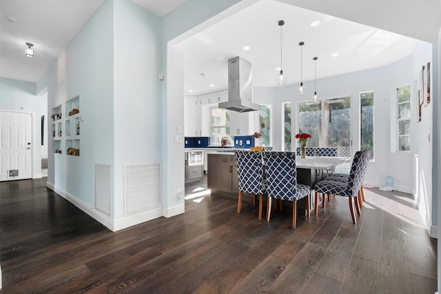 dining space with dark wood-type flooring, visible vents, and baseboards