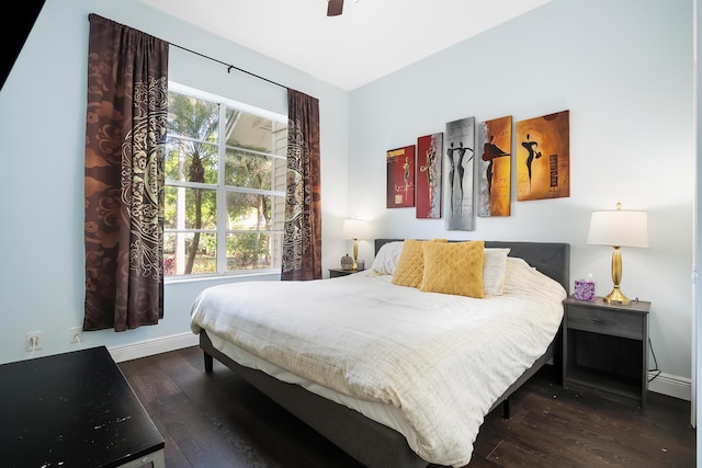 bedroom featuring multiple windows, baseboards, and wood finished floors