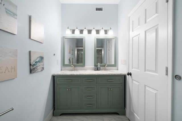 bathroom featuring double vanity, visible vents, marble finish floor, a shower stall, and a sink