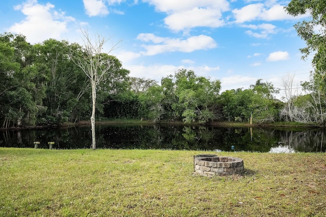 view of yard with a water view and an outdoor fire pit