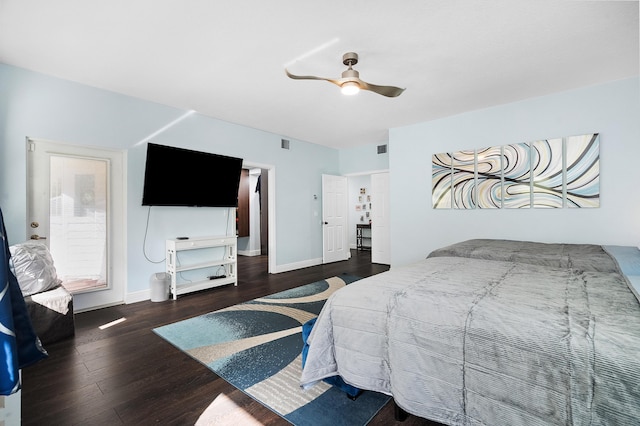 bedroom with a ceiling fan, visible vents, baseboards, and wood finished floors