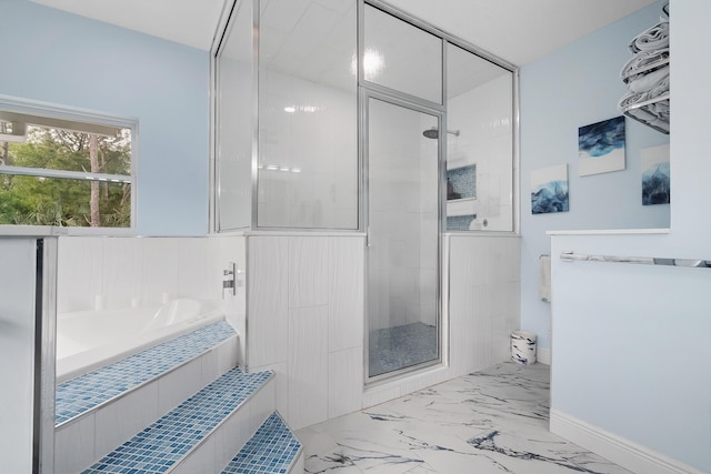 bathroom featuring a garden tub, marble finish floor, a shower stall, and baseboards