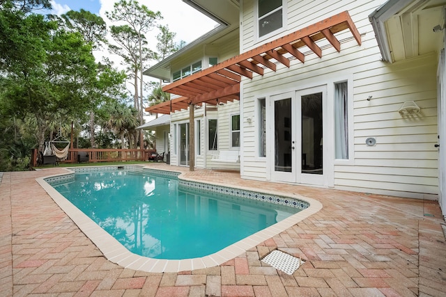 view of pool with a patio area, a fenced in pool, and french doors