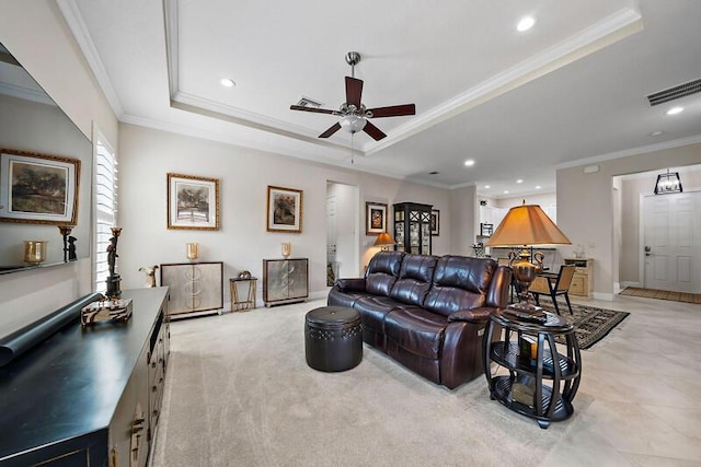 living area with visible vents, a ceiling fan, ornamental molding, a tray ceiling, and recessed lighting