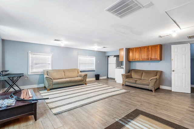 living area featuring a wealth of natural light, wood finished floors, and visible vents