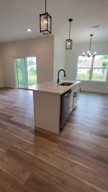 kitchen with white cabinets, dishwasher, a wealth of natural light, and a sink