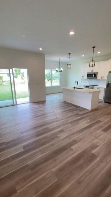 kitchen featuring recessed lighting, stainless steel appliances, a sink, white cabinetry, and open floor plan