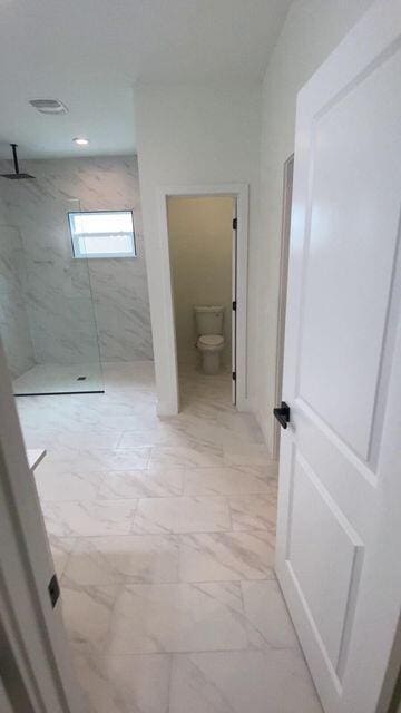 full bathroom featuring marble finish floor, visible vents, toilet, and a marble finish shower