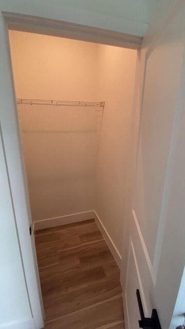 walk in closet with wood finished floors