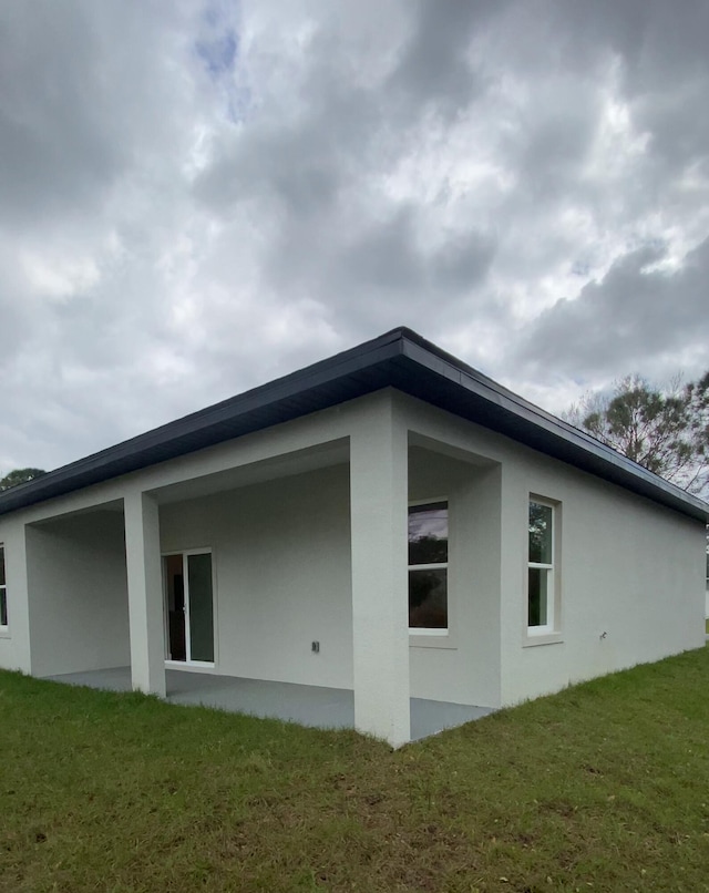 view of property exterior with a yard and stucco siding