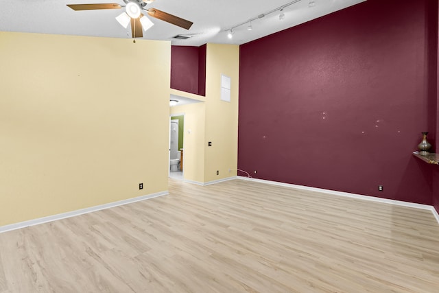 unfurnished room featuring light wood finished floors, visible vents, baseboards, ceiling fan, and high vaulted ceiling