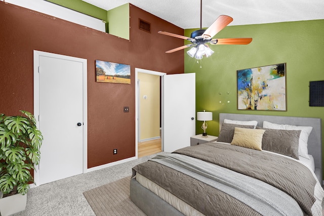 bedroom featuring high vaulted ceiling, a ceiling fan, visible vents, and carpet flooring