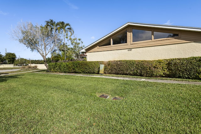 view of home's exterior with a yard and stucco siding