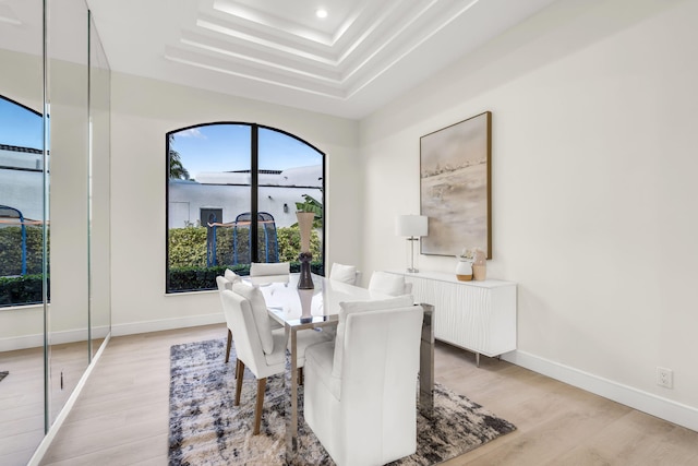 dining area with a tray ceiling, recessed lighting, baseboards, and light wood finished floors