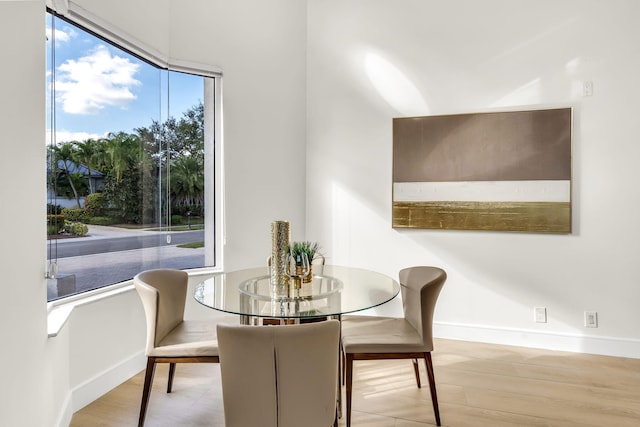 dining area with baseboards and wood finished floors