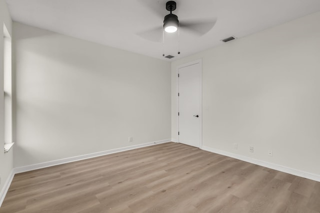 unfurnished room with baseboards, visible vents, a ceiling fan, and light wood-style floors