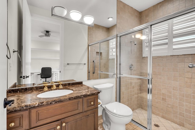 full bathroom featuring a stall shower, toilet, and vanity