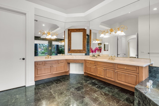 full bath with a sink, a chandelier, and double vanity