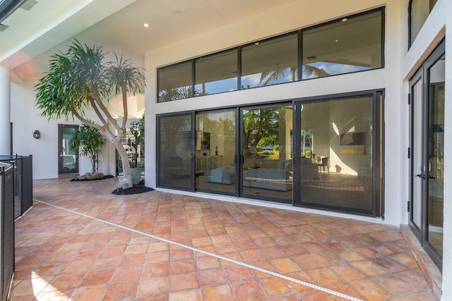 view of exterior entry featuring a patio area and stucco siding