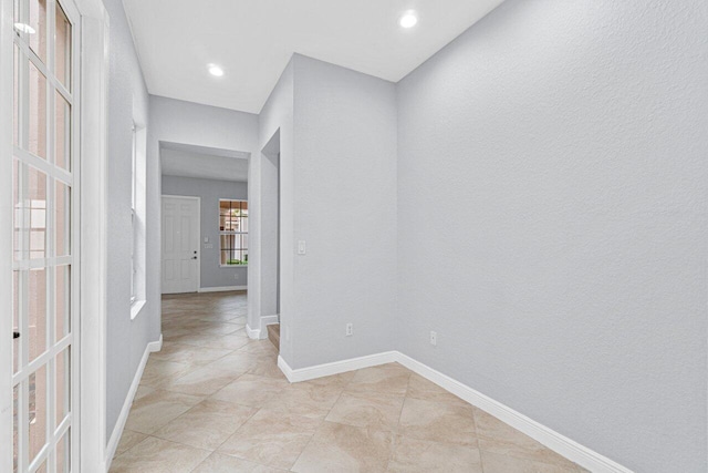 corridor featuring baseboards and recessed lighting