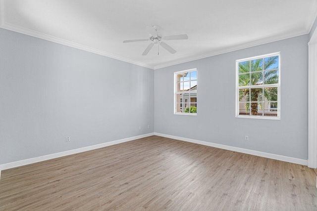 spare room featuring ornamental molding, light wood-type flooring, a ceiling fan, and baseboards