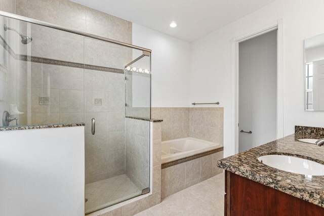 bathroom featuring a garden tub, tile patterned flooring, a sink, a shower stall, and double vanity