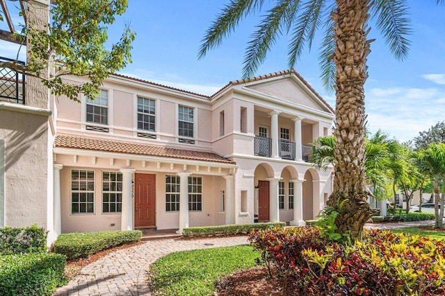 view of front of house featuring a balcony and stucco siding
