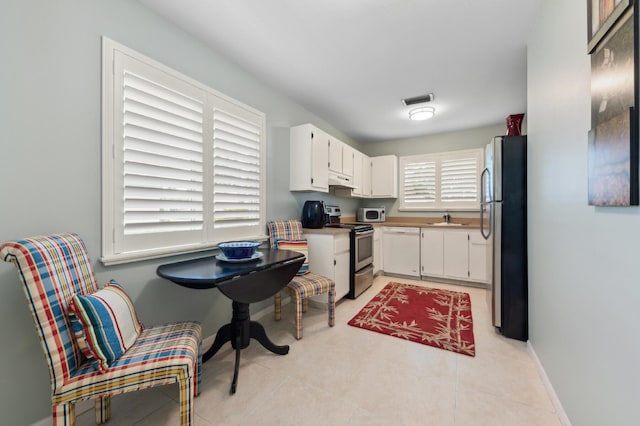 kitchen with a sink, visible vents, baseboards, white cabinets, and appliances with stainless steel finishes