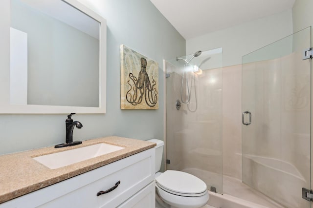 bathroom with toilet, a stall shower, and vanity