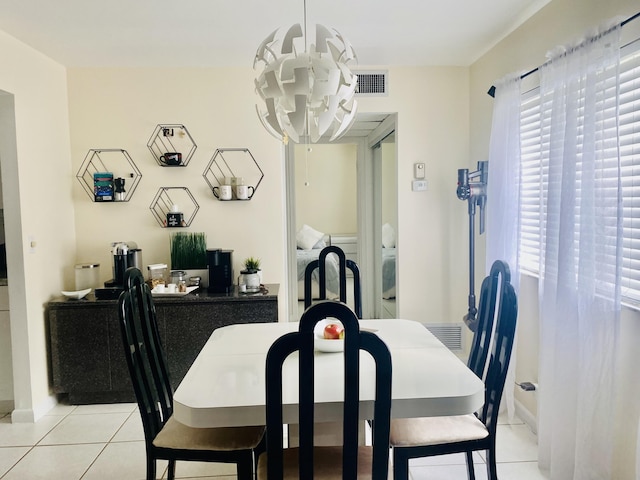 dining space with light tile patterned floors, visible vents, and a notable chandelier