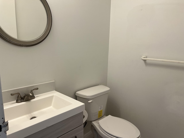 half bath featuring toilet and vanity