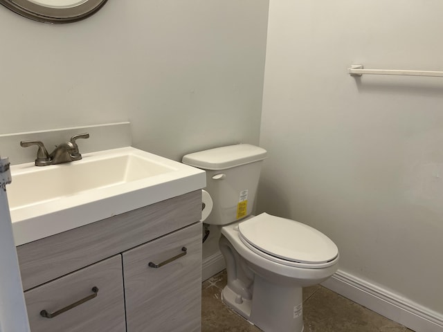 bathroom featuring tile patterned floors, baseboards, toilet, and vanity