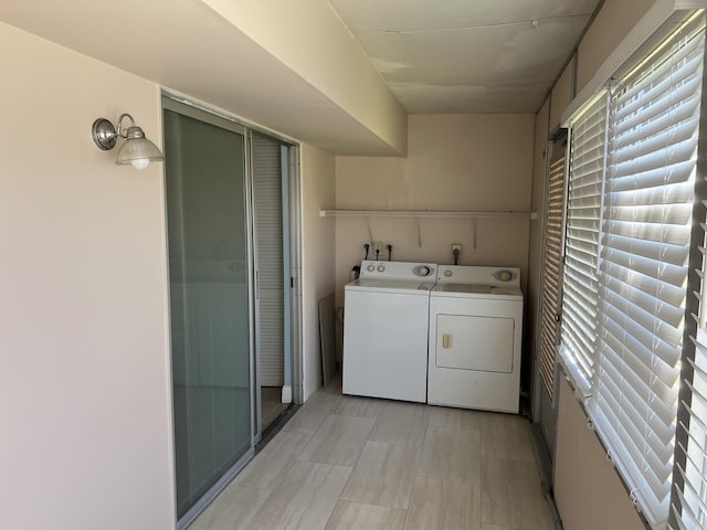 clothes washing area with a wealth of natural light and washing machine and dryer