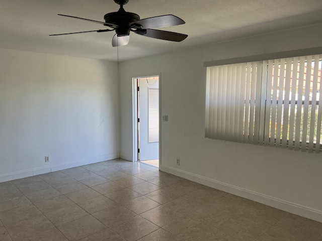 unfurnished room with tile patterned floors, baseboards, a healthy amount of sunlight, and ceiling fan