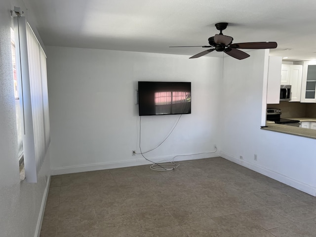 unfurnished room with baseboards and ceiling fan