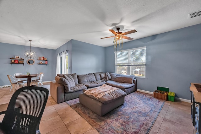 living room featuring light tile patterned floors, plenty of natural light, visible vents, and a textured ceiling